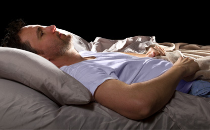 Man lying in bed with insomnia