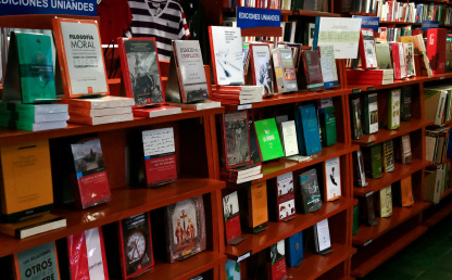 A shelf full of books that are published by the Uniandes publishing house.